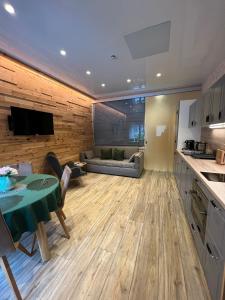 a kitchen and living room with a table and a couch at Alpenburg Bergparadies Apartments in Wald am Arlberg