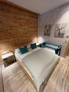 a bedroom with a large bed with a wooden wall at Alpenburg Bergparadies Apartments in Wald am Arlberg