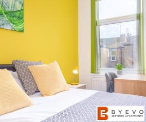 a bedroom with a bed with yellow walls and a window at ByEvo Darwin House - Contractor pad or Family getaway - Close to Thonock Park Golf Course in Gainsborough