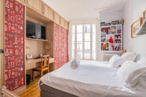 a bedroom with a large white bed and a desk at Veeve - Impressions of the Eiffel Tower in Paris