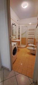 a bathroom with a shower and a washing machine at Apartments Tony in Bardolino in Bardolino