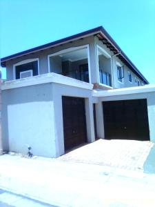Casa blanca grande con 2 puertas de garaje en Mkhandi Self Catering en Durban