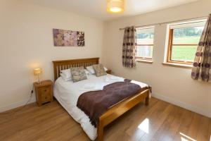 a bedroom with a bed and a window at Beech Cottage at Williamscraig Holiday Cottages in Linlithgow