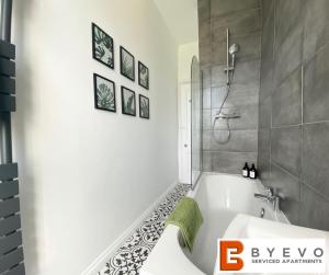 ein Badezimmer mit einer weißen Badewanne und einer Dusche in der Unterkunft ByEvo 19 Walker - perfect for contractors - close to GLA in Paisley