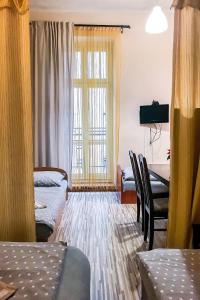 pokój z dwoma łóżkami, stołem i oknem w obiekcie Apartaments Piotrkowska 101 w Łodzi