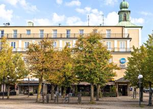 un grand bâtiment avec des arbres devant lui dans l'établissement Best Western Motala Stadshotell, à Motala