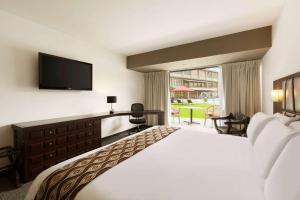 um quarto de hotel com uma cama e uma televisão de ecrã plano em Costa del Sol Wyndham Trujillo em Trujillo