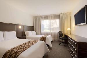 um quarto de hotel com duas camas e uma televisão em Costa del Sol Wyndham Trujillo em Trujillo