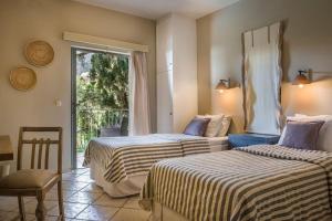 een hotelkamer met 2 bedden en een raam bij Unique Kefalonia Ionian Sands Villa in Lourdhata