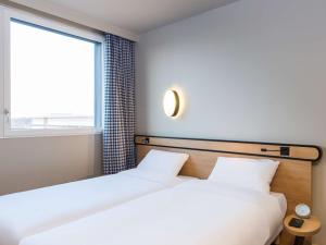 dwa łóżka w pokoju z oknem w obiekcie Aparthotel Adagio access Palaiseau Saclay w mieście Palaiseau