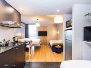 帕萊索的住宿－Aparthotel Adagio access Palaiseau Saclay，厨房、带厨房的客厅和卧室