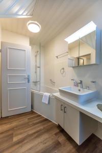 a bathroom with a sink and a mirror at Ferienwohnung Klintum in Oldsum