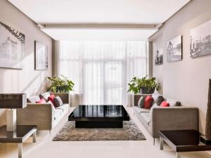 uma sala de estar com dois sofás e uma mesa de centro em Mövenpick Hotel Casablanca em Casablanca