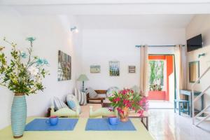 a living room with a table and flowers in a room at LEFKES Apartments Sidari in Sidari