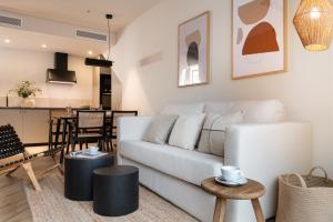 sala de estar con sofá blanco y mesa en Magno Apartments Robles with Bath Tub and Private Parking en Sevilla