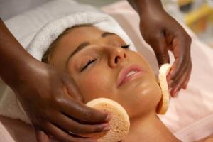 a woman getting her face washed with a towel at Abalone Hotel & Villas in Paternoster