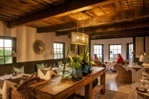 een eetkamer met tafels en mensen aan tafels bij Abalone Hotel & Villa's in Paternoster