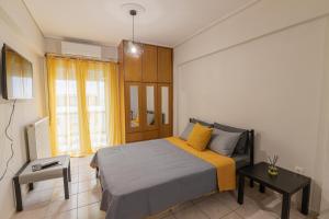 a bedroom with a bed and a table and a window at SUGARAKIS B in Volos