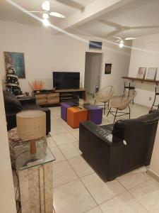 een woonkamer met banken en een flatscreen-tv bij Eco Isla GuestHouse in Florianópolis
