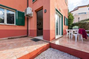 un patio con mesa y sillas fuera de un edificio en A Muredda di Lozari, en Belgodère