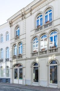 een wit gebouw met ramen en balkons aan een straat bij B&B Yasmine Brugge in Brugge