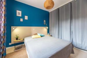 una camera da letto con un grande letto con pareti blu di A Muredda di Lozari a Belgodère