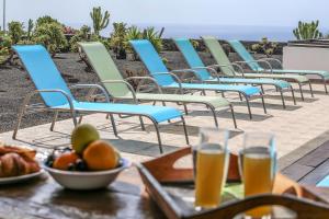 a bunch of chairs sitting on a table with drinks at Villa Horizon Sunset y Ocean Lanzarote in Mácher