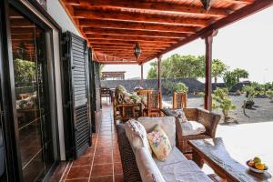 a porch with a couch and chairs on a patio at Villa Horizon Sunset y Ocean Lanzarote in Mácher