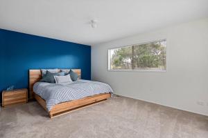 1 dormitorio con 1 cama con pared azul en Dana Beach House, Blairgowrie, en Blairgowrie