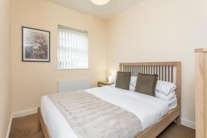 a bedroom with a large white bed and a window at The Fusiliers in Leyland