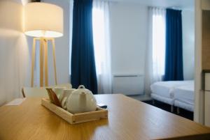 una habitación con una mesa con una tetera en Appart' hôtel 7 sensation, en Bougival