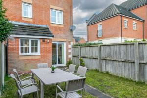 a backyard with a table and chairs and a fence at The Fusiliers in Leyland