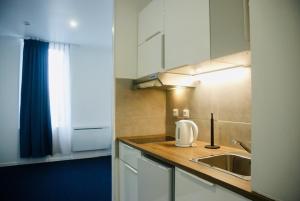 a kitchen with a sink and a counter top at Appart' hôtel 7 sensation in Bougival
