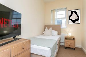 a bedroom with a bed and a flat screen tv at The Fusiliers in Leyland