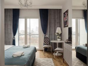 Schlafzimmer mit einem Bett, einem Schreibtisch und einem Fenster in der Unterkunft Prymasa Tysiąclecia 83A (D) by Perfect Apart in Warschau