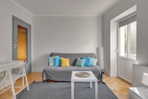 a bedroom with a bed with blue and yellow pillows at Prima - apartament w Sopocie by Grand Apartments in Sopot