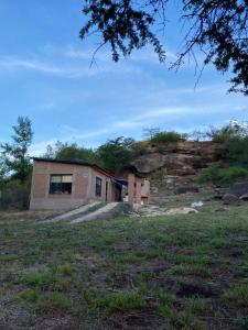 a house on top of a hill in a field at La Reserva in Villa Parque Siquiman