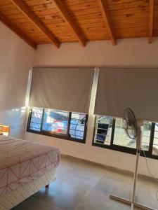 1 dormitorio con ventilador en una habitación con ventanas en La Reserva en Villa Parque Siquiman