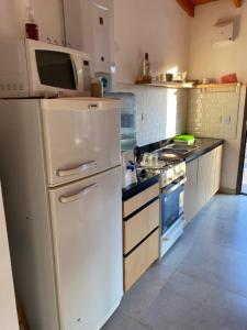 a kitchen with a white refrigerator and a microwave at La Reserva in Villa Parque Siquiman