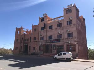 um carro branco estacionado em frente a um edifício em Hotel Rayyan l 'Escale em Uarzazate