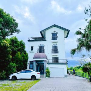a white car parked in front of a white house at Landay Homestay in Yilan City