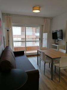 a living room with a couch and a table at Apartamentos Regollera Premium con garaje in Noja