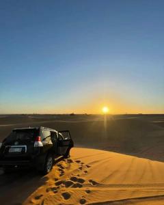 ザゴラにあるDesert Campの砂漠の砂に停められた車