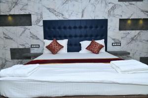 a bedroom with a large white bed with red pillows at Hotel Lake View in Port Blair