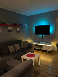 een woonkamer met een bank en een flatscreen-tv bij Gdynia Apartament 42 m z miejscem w Garażu z Windą blisko centrum i morza in Gdynia