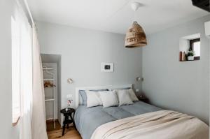 a bedroom with a bed with white walls at Lindhouse - Country House a Govone in Govone
