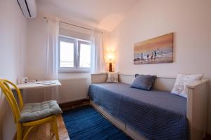 een kleine slaapkamer met een bed en een raam bij Spacious Chic Residence in Zadar