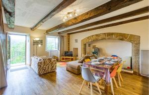 a living room with a table and a fireplace at Awesome Home In Castelnau-d-mandailles With Outdoor Swimming Pool, Wifi And 2 Bedrooms in Castelnau-de-Mandailles