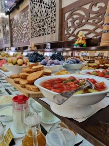ein Buffet mit Schalen Essen auf dem Tisch in der Unterkunft Hotel Asia Bukhara in Buxoro