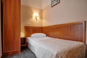 a bedroom with a bed with a wooden head board at Hotel Lovran in Lovran